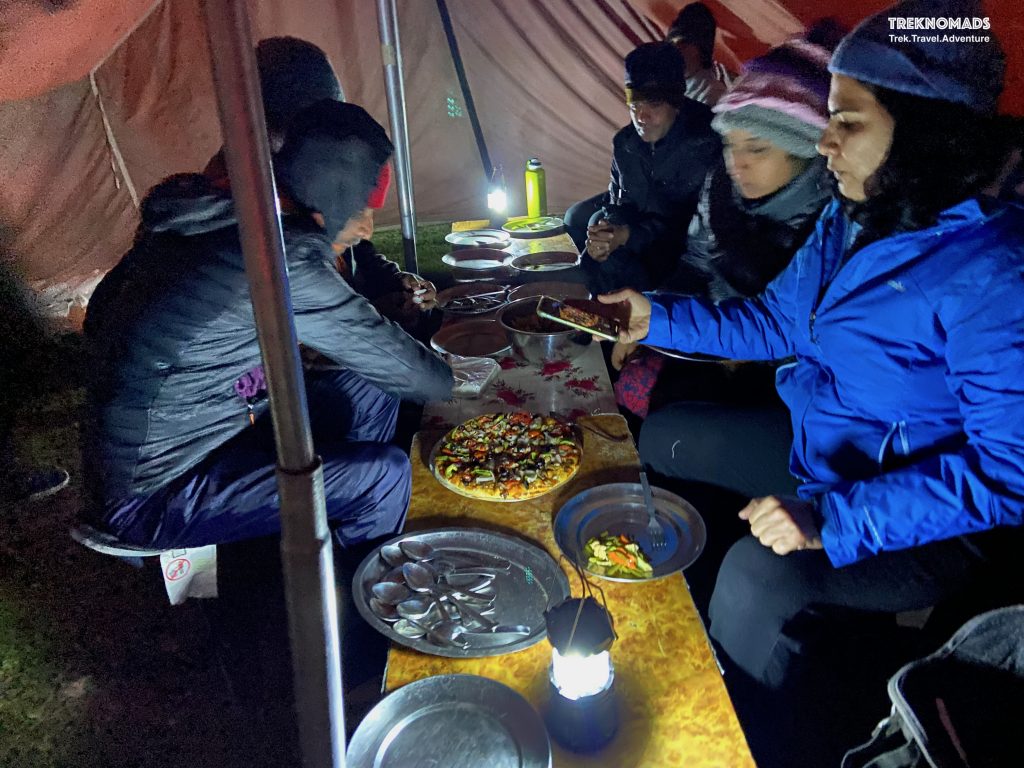 Our team enjoying freshly backed pizza at Nichnai Camp. Kashmir Great Lakes Trek - Premium
